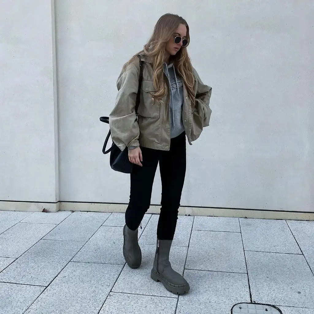 Olive green utility jacket over grey hoodie with black skinny pants and grey chunky boots