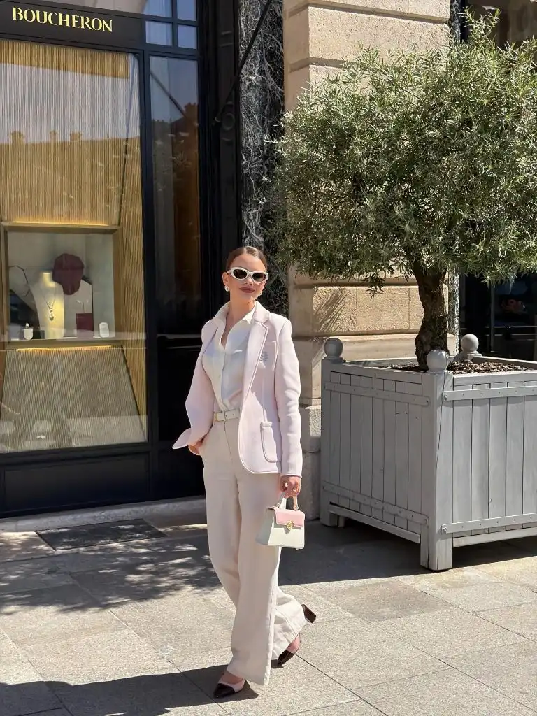All cream outfit with pink blazer outside Boucheron