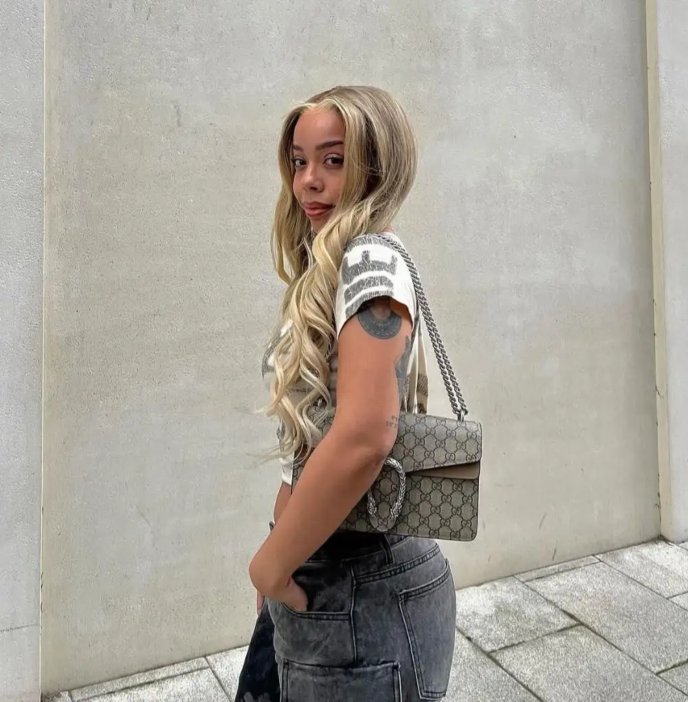 Fall Hair Colors for Black Women 2026 Platinum Blonde Waves With a Gucci Bag and an Attitude