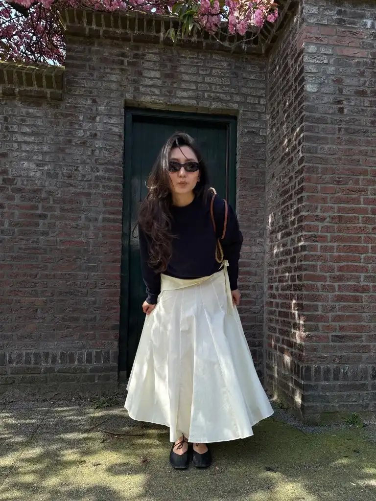 Modest fall outfit with navy sweater and cream pleated skirt