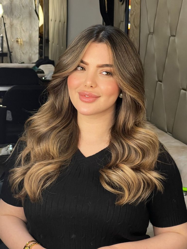 Warm bronde balayage with soft waves and lighter face-framing pieces