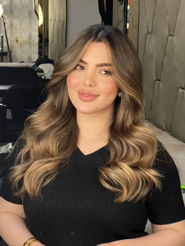Warm bronde balayage with soft waves and lighter face-framing pieces