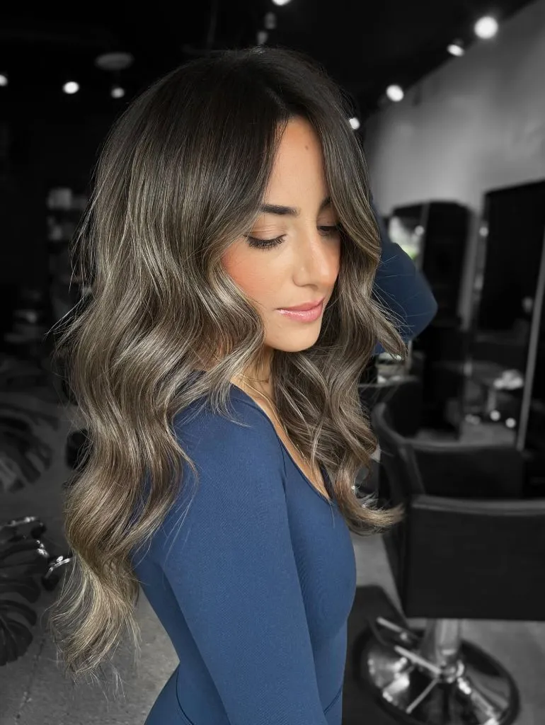 Dark cool-toned balayage melting into smoky silver-blonde waves
