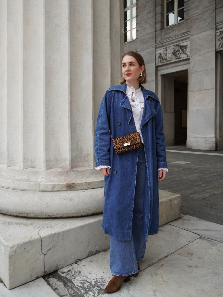 Blue denim trench coat over denim wide-leg jeans with leopard bag