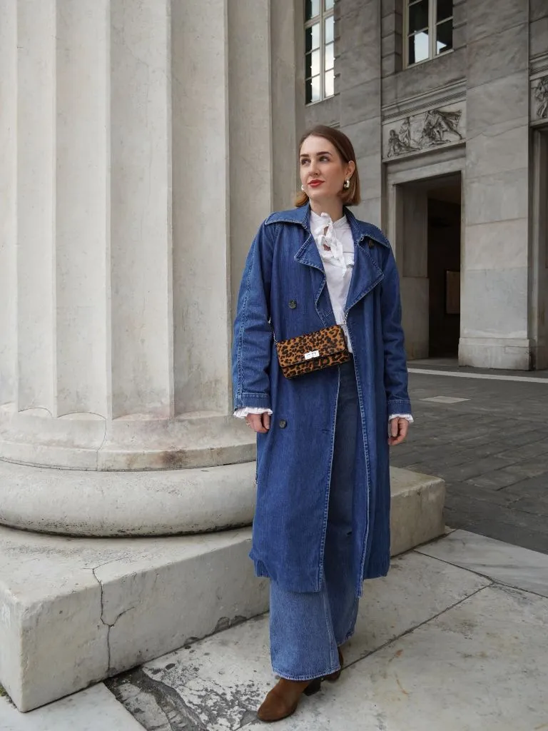 Blue denim trench coat over denim wide-leg jeans with leopard bag