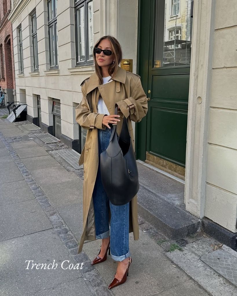 Tan trench coat over white tee with cuffed jeans, black hobo bag, and brown slingbacks