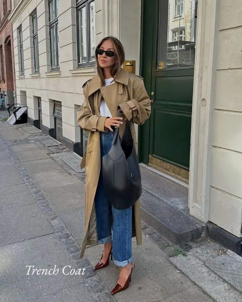 Tan trench coat over white tee with cuffed jeans, black hobo bag, and brown slingbacks