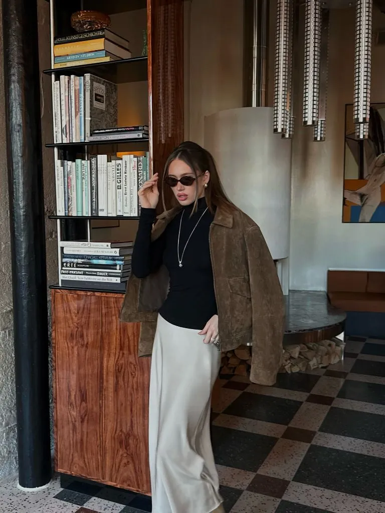Black turtleneck with champagne satin skirt and brown suede jacket