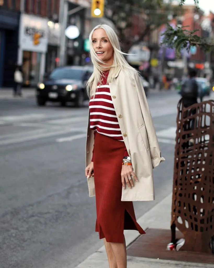 Red and white striped knit sweater with burgundy knit midi skirt and trench coat