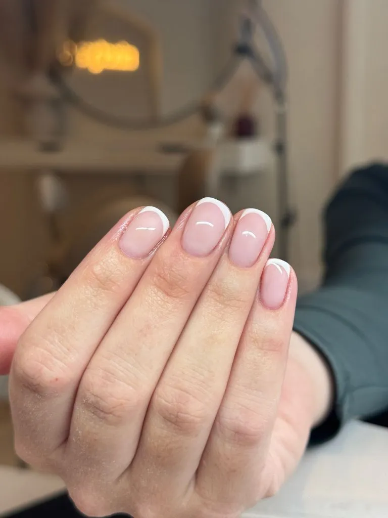 Classic French manicure with thin white tips on short round nails August nails color 2026 ideas