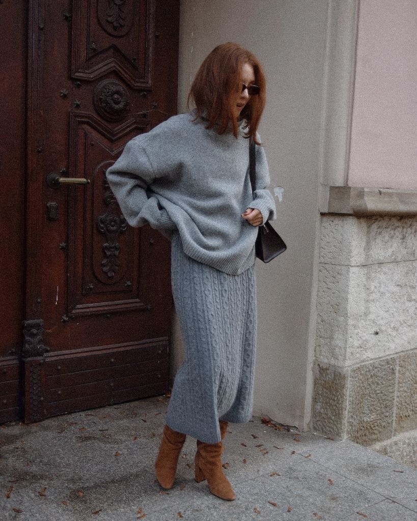 Grey cable-knit midi skirt with oversized grey sweater and tan boots