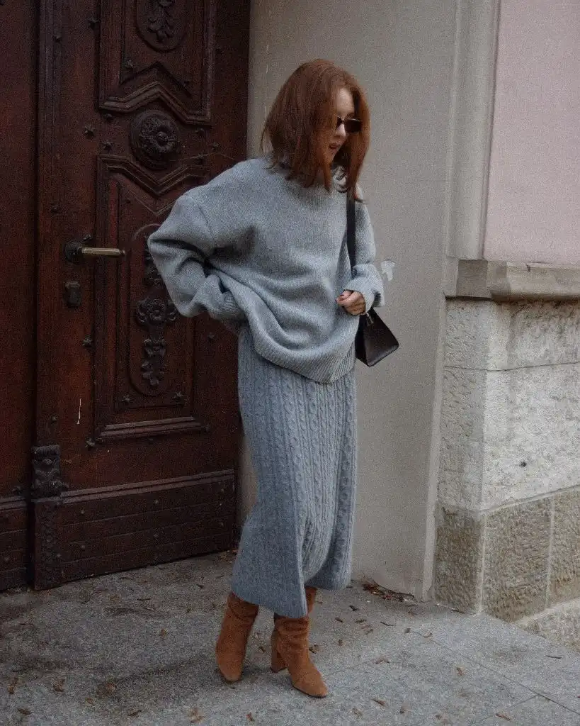 Grey cable-knit midi skirt with oversized grey sweater and tan boots