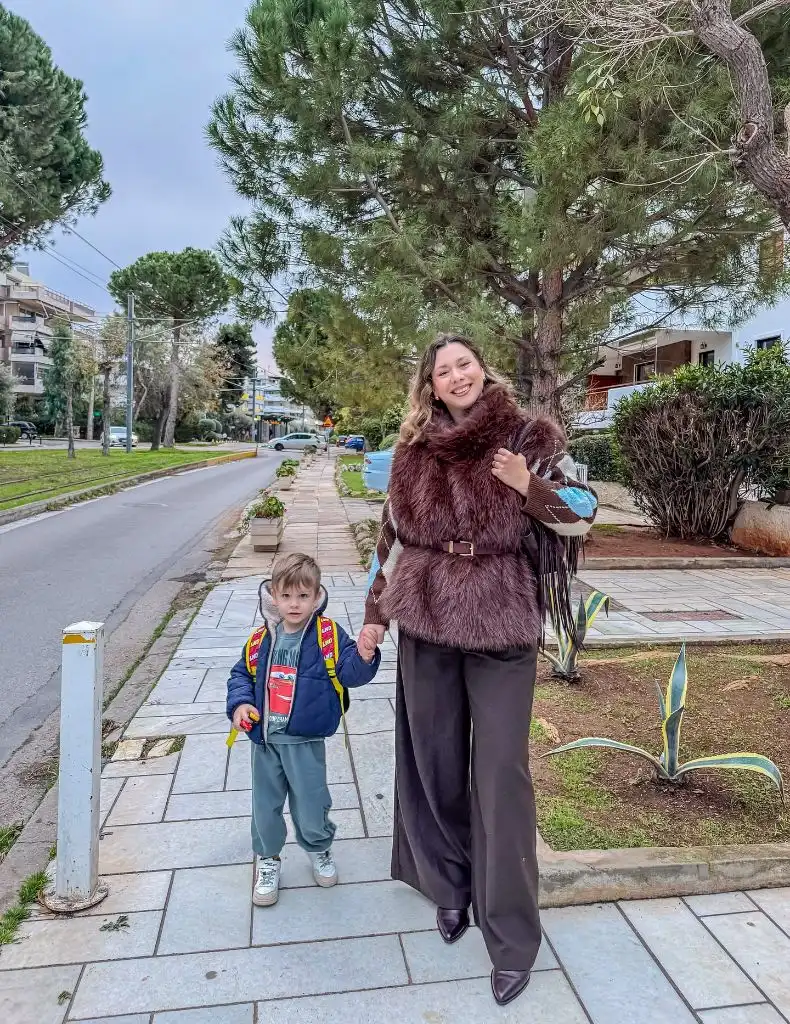 Mom walking with child in burgundy faux fur vest