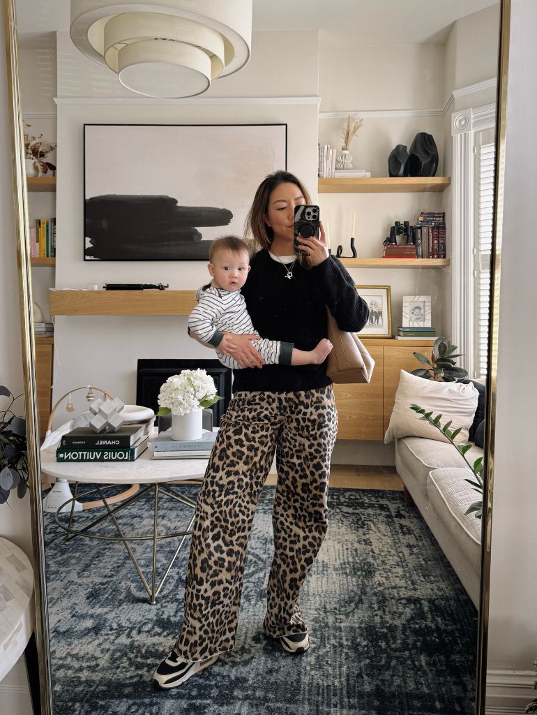 Mirror selfie with baby in black top and leopard print pants