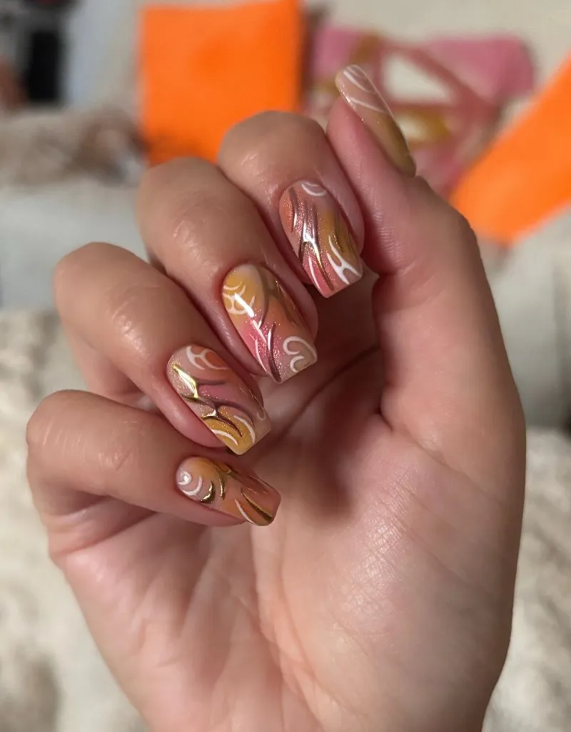 Abstract warm amber and gold swirl nail art, trendy August nails ideas 2026