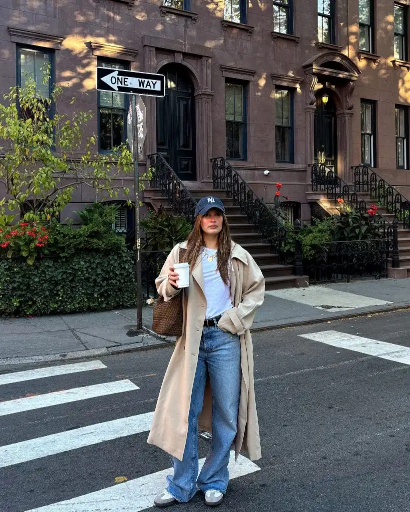 Beige trench coat with NY Yankees cap and wide-leg jeans