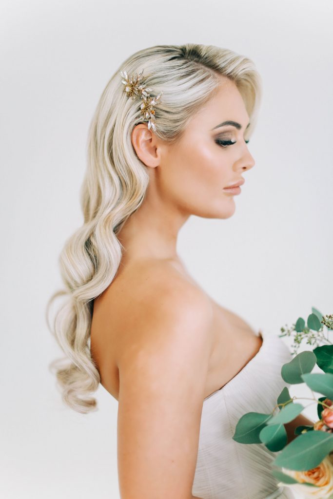 Woman with polished classic Hollywood waves in a deep side part