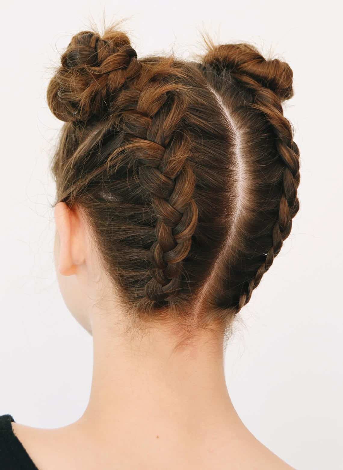 Back view of Dutch braids feeding into two braided space buns