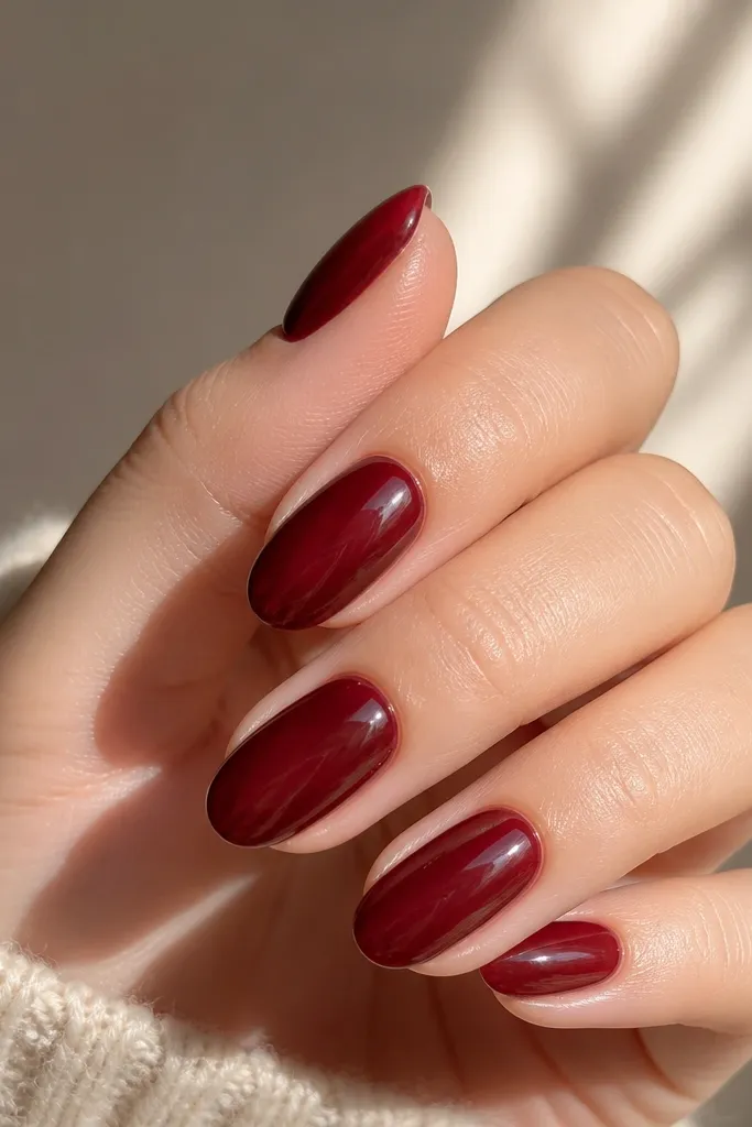 Short almond nails in a translucent cherry jelly over a deeper wine base