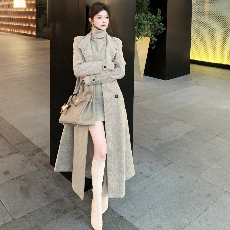 Woman in a turtleneck sweater dress with knee-high boots and a coat