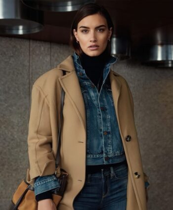 Woman wearing a cropped denim jacket layered under a camel coat with a black turtleneck and jeans