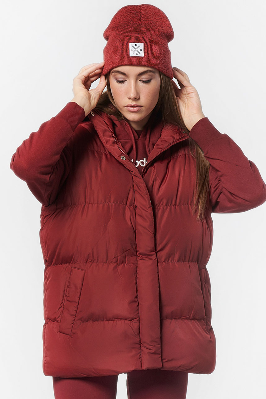 Woman in a puffer vest over a hoodie with leggings
