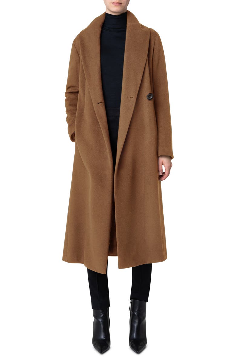 Woman in a cocoa brown long wool coat with black turtleneck, black trousers and black pointed boots