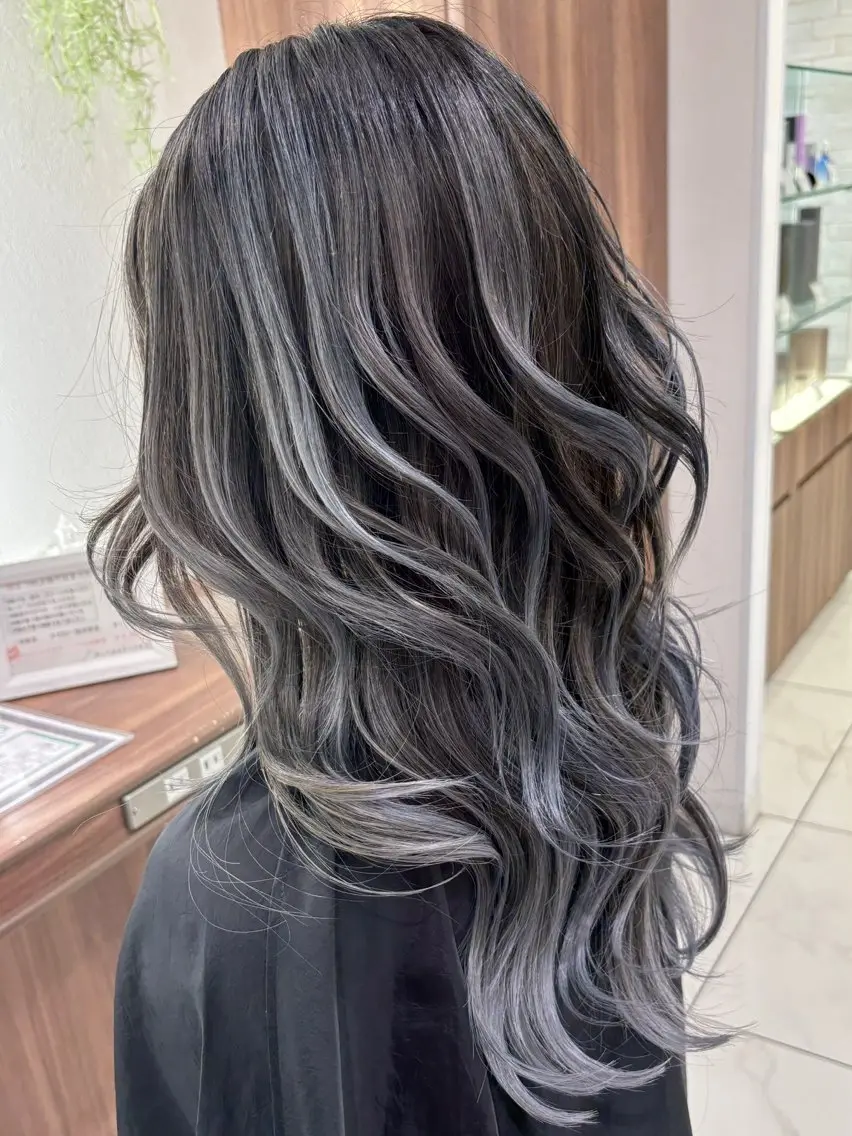 Charcoal silver balayage on long wavy gray hair