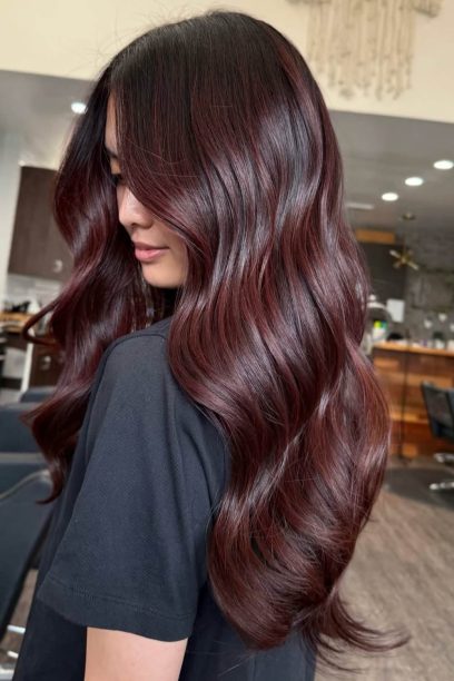 Side view of long wavy near-black hair with cherry red ribbons