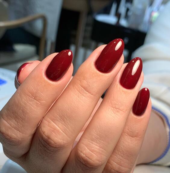 Short almond nails in glossy deep red polish