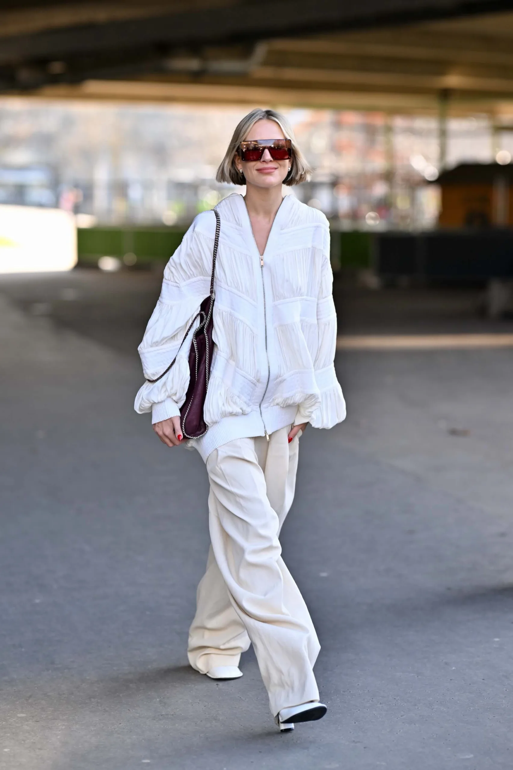 Woman in a white quilted puffer jacket with cream wide-leg trousers
