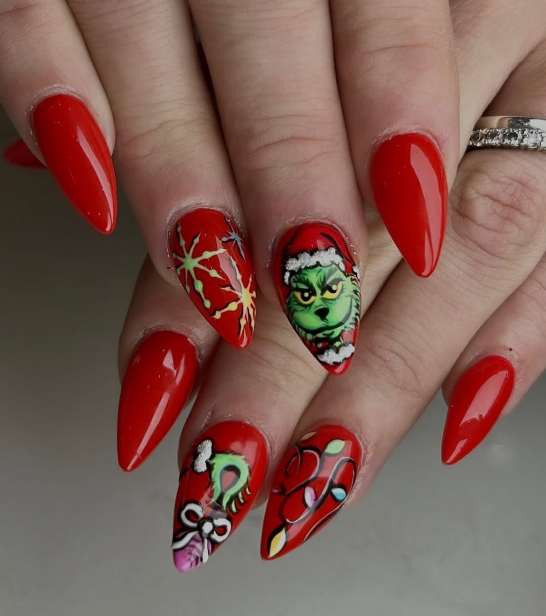 Stiletto nails in neon green with Grinch nail art
