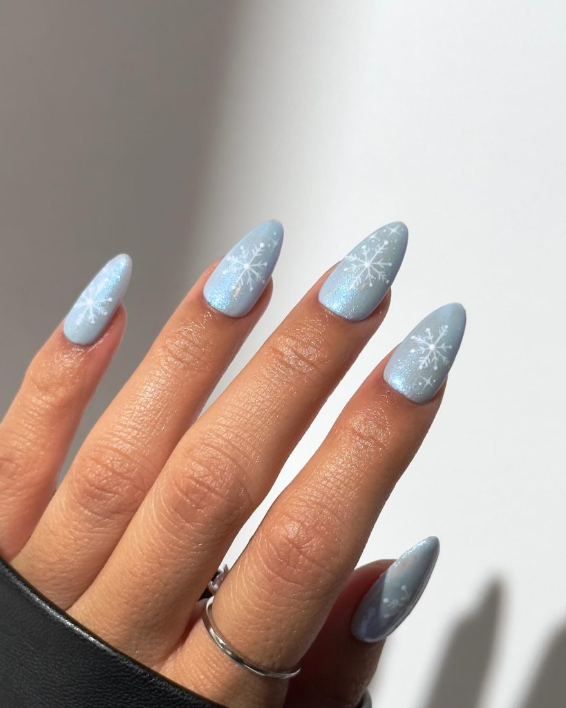 Light blue almond nails with delicate white snowflake nail art