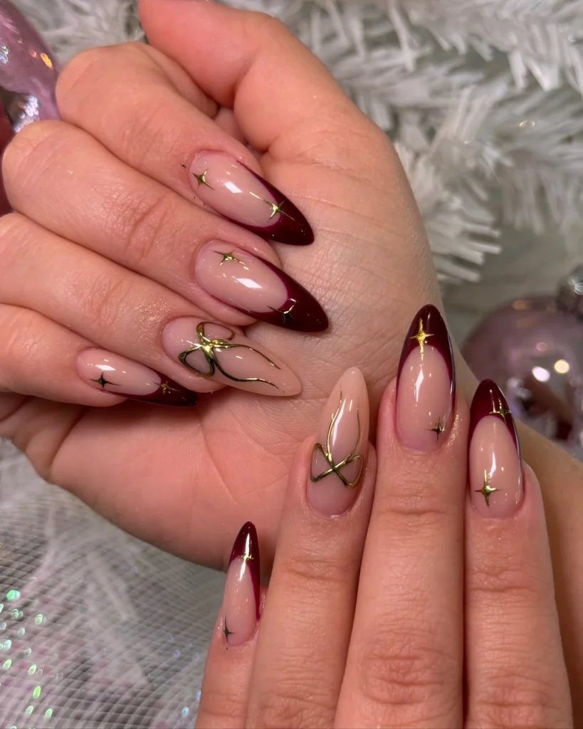 Deep burgundy ombre almond nails with scattered gold foil flecks