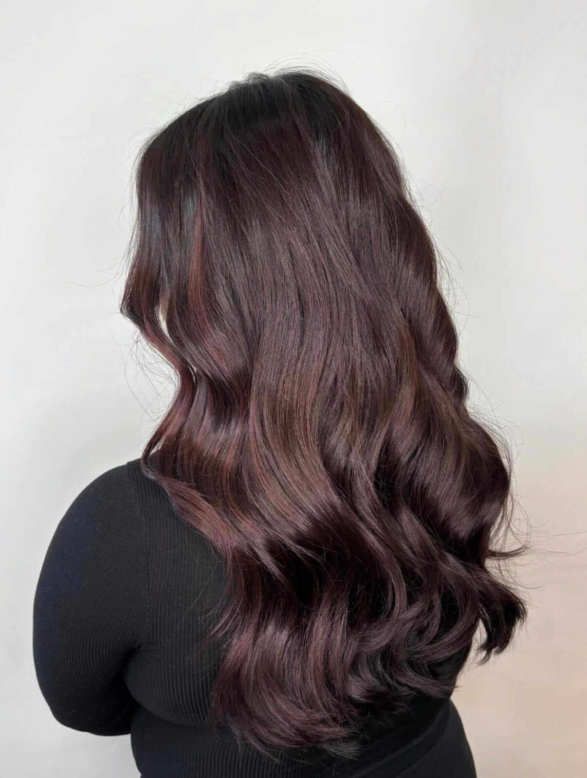 Deep merlot-mahogany waves on medium-long hair, back view