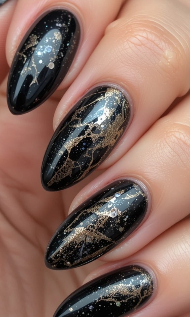Glossy Black with Gold Foil Veining: black almond nails with marble-like gold veins and glitter
