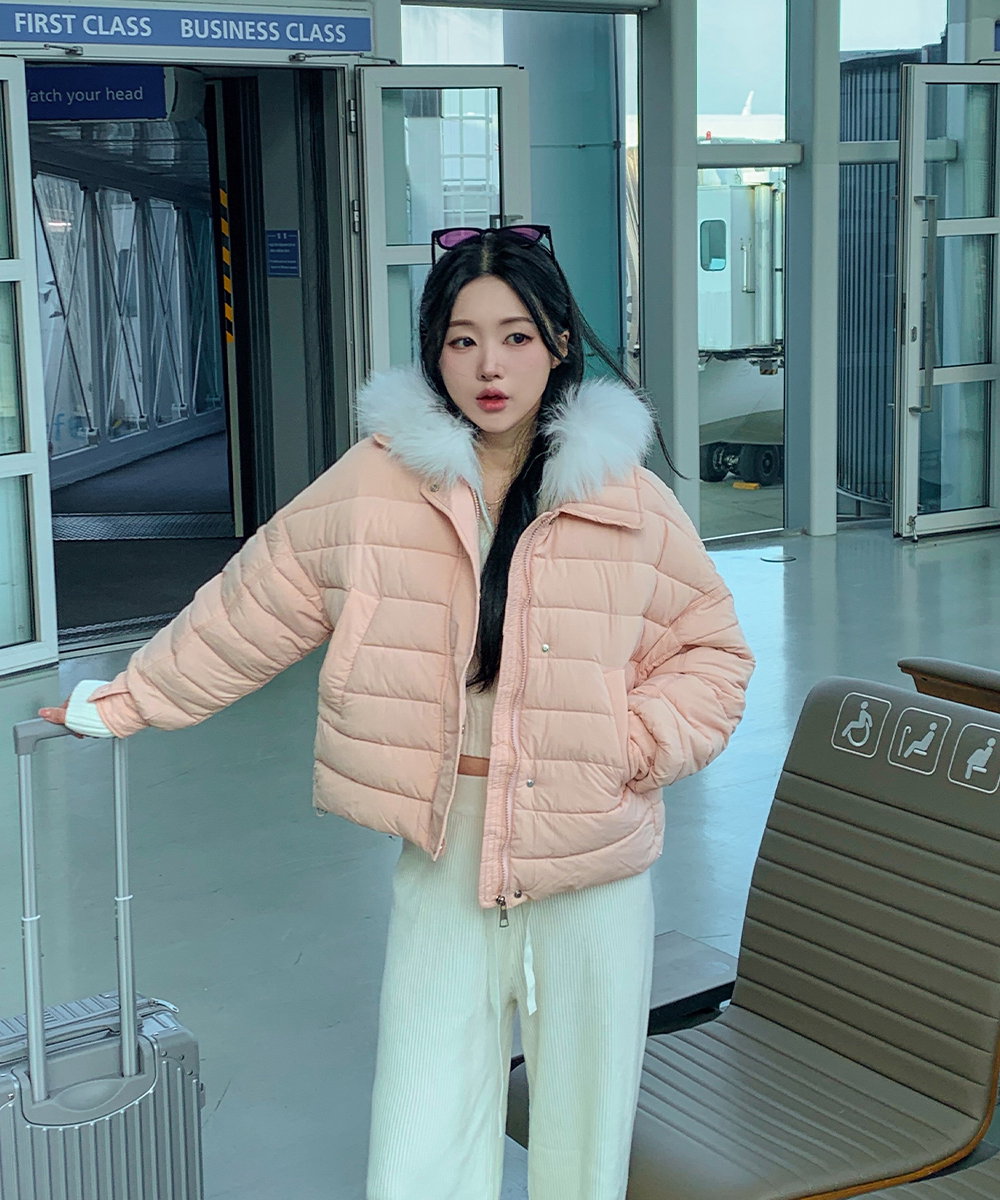 Woman wearing a puffer jacket outfit, colorful winter travel look