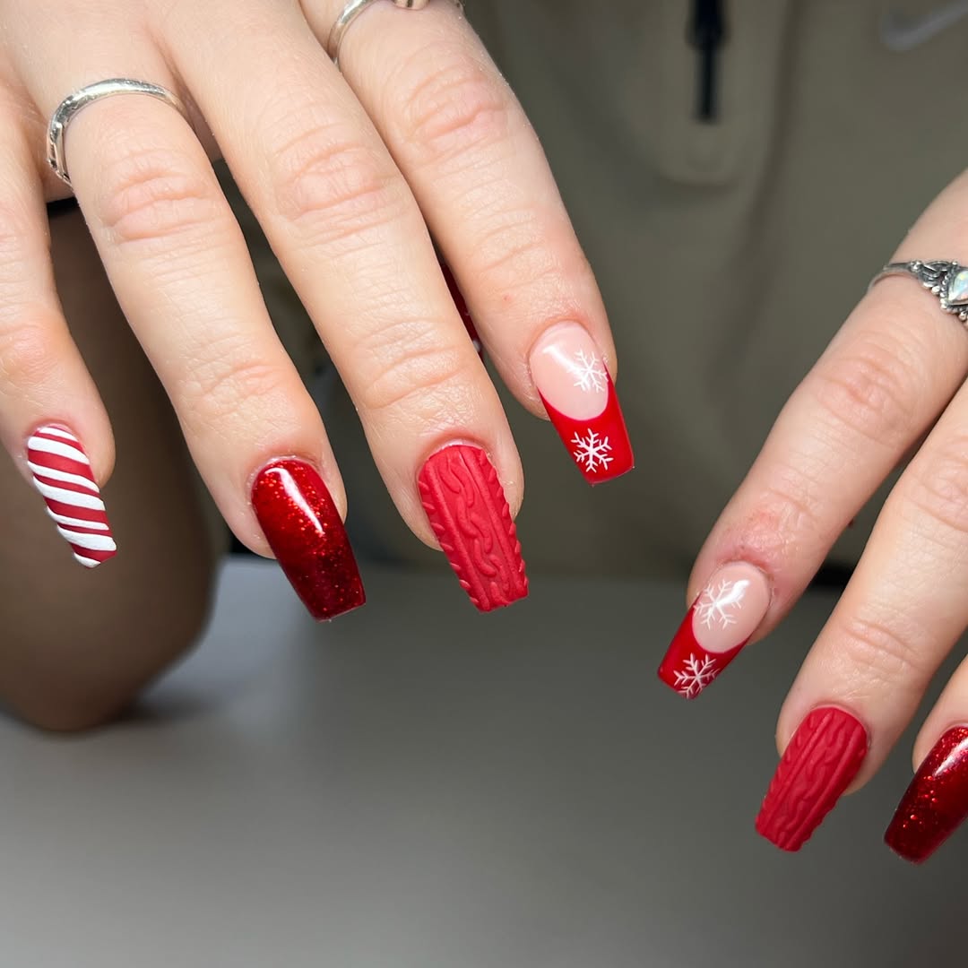 Long coffin nails in a red Christmas mix with candy cane stripes, sweater knit texture, snowflake french tips and red glitter