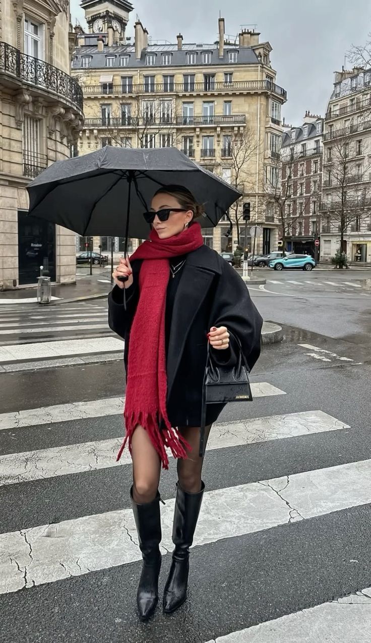 Woman in a black coat with a scarf in a European winter look