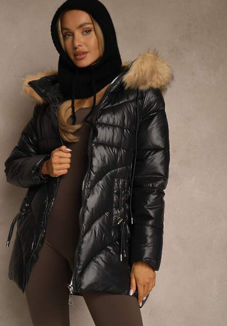 Woman wearing a black glossy puffer parka with a faux-fur hood and a black knit balaclava