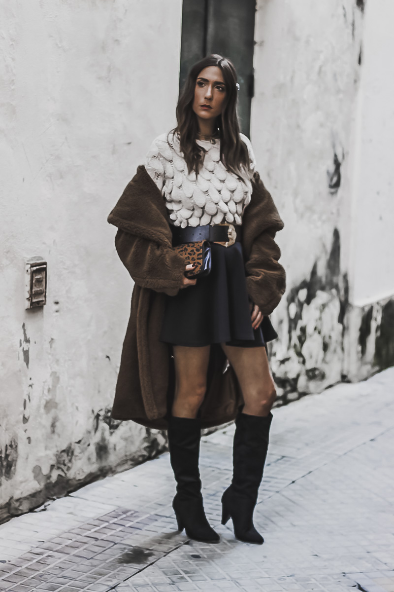 Woman in a teddy coat with a mini skirt and boots