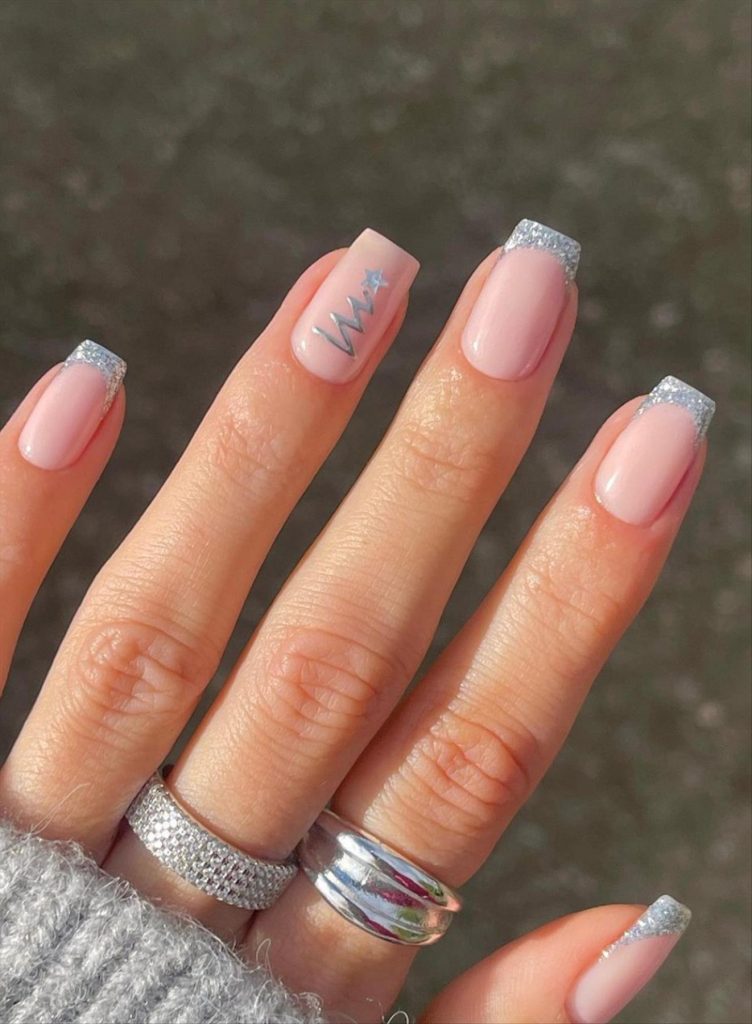 Short nude pink Christmas nails with silver glitter French tips