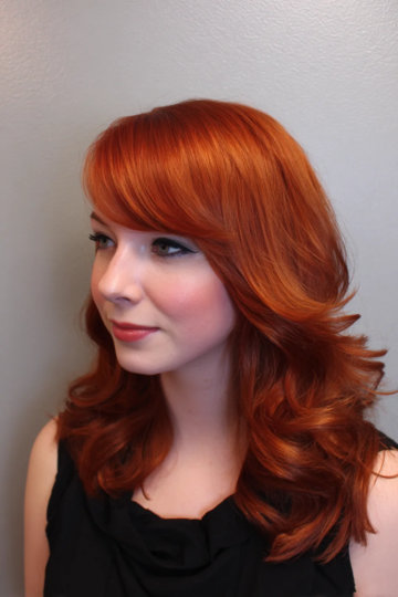 Shoulder-length copper red hair with side-swept bangs