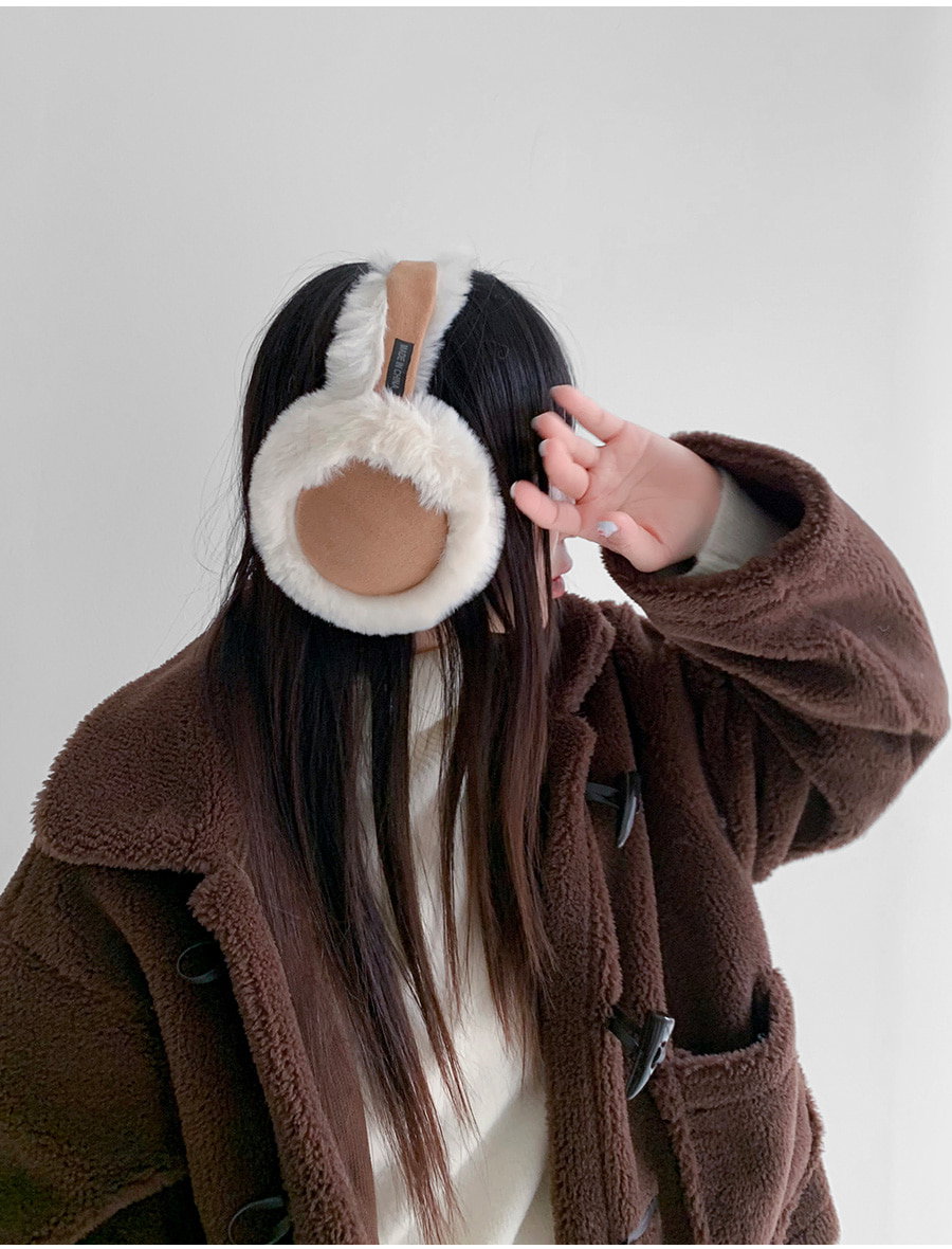 Woman wearing mink-color earmuffs and a brown teddy coat