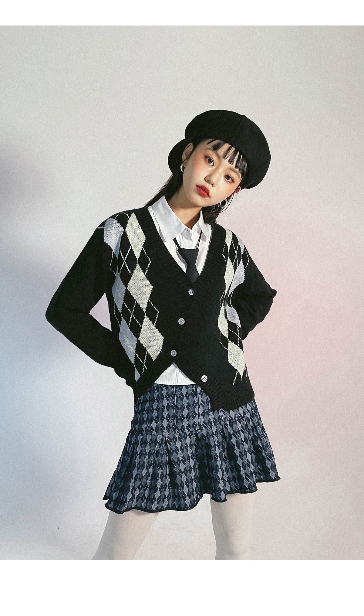 Woman wearing argyle tights with a pleated skirt and cardigan in a preppy outfit