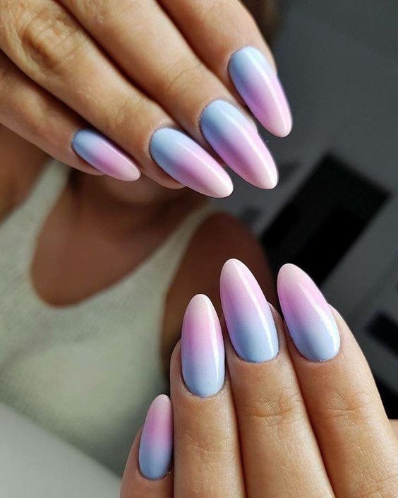Long oval nails fading from soft lilac near the cuticle into periwinkle blue tips with a glossy finish