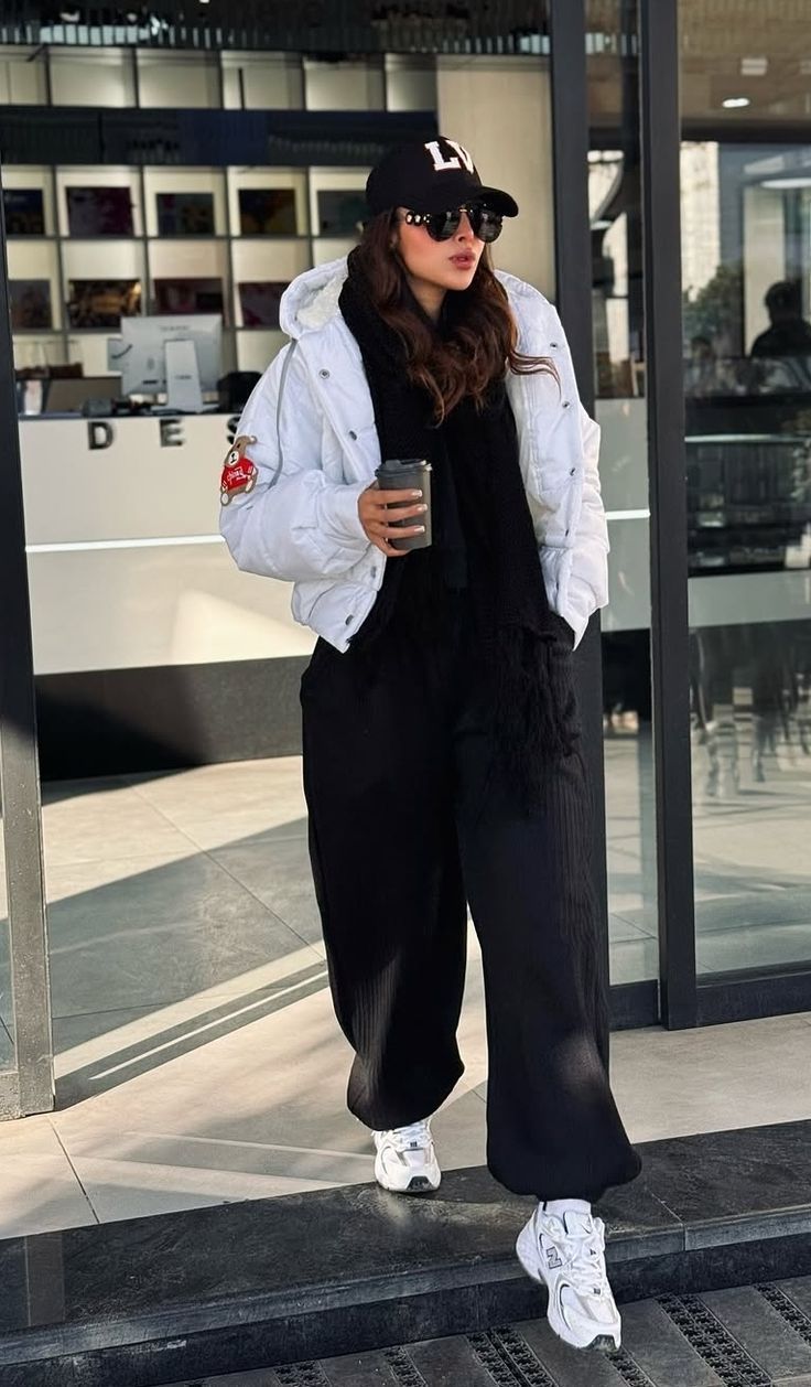Woman in a hoodie dress with a puffer vest, leggings and sneakers