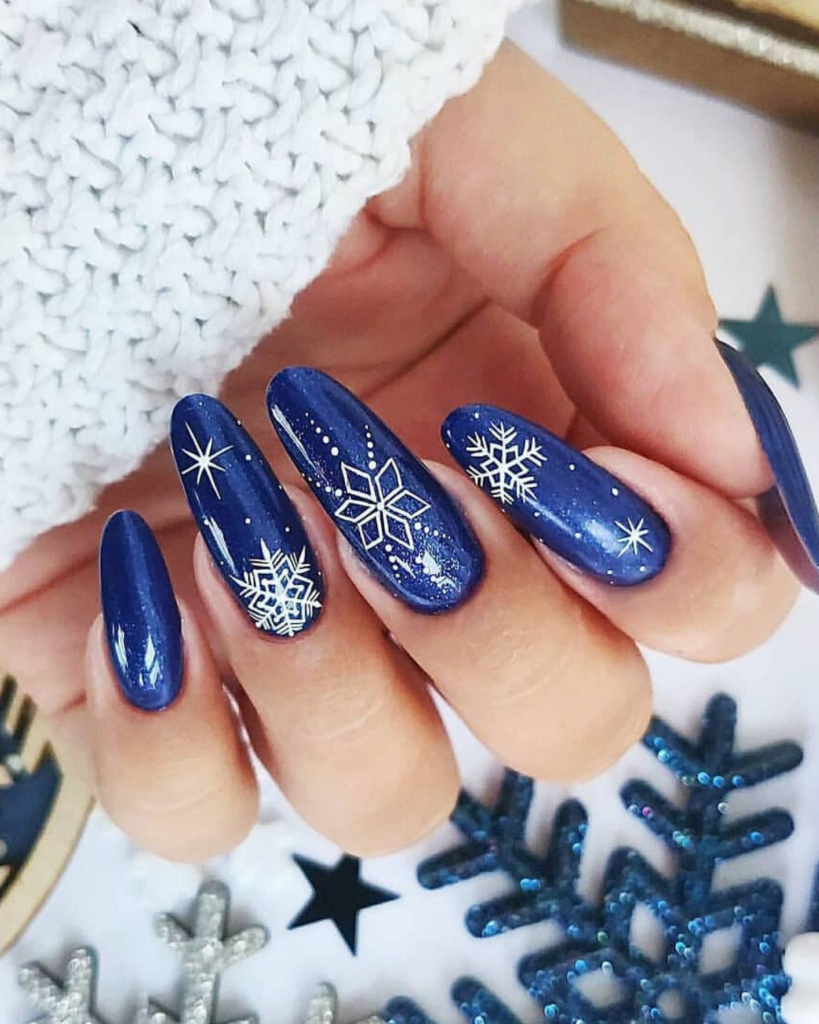 Short oval deep navy nails with white snowflake nail art