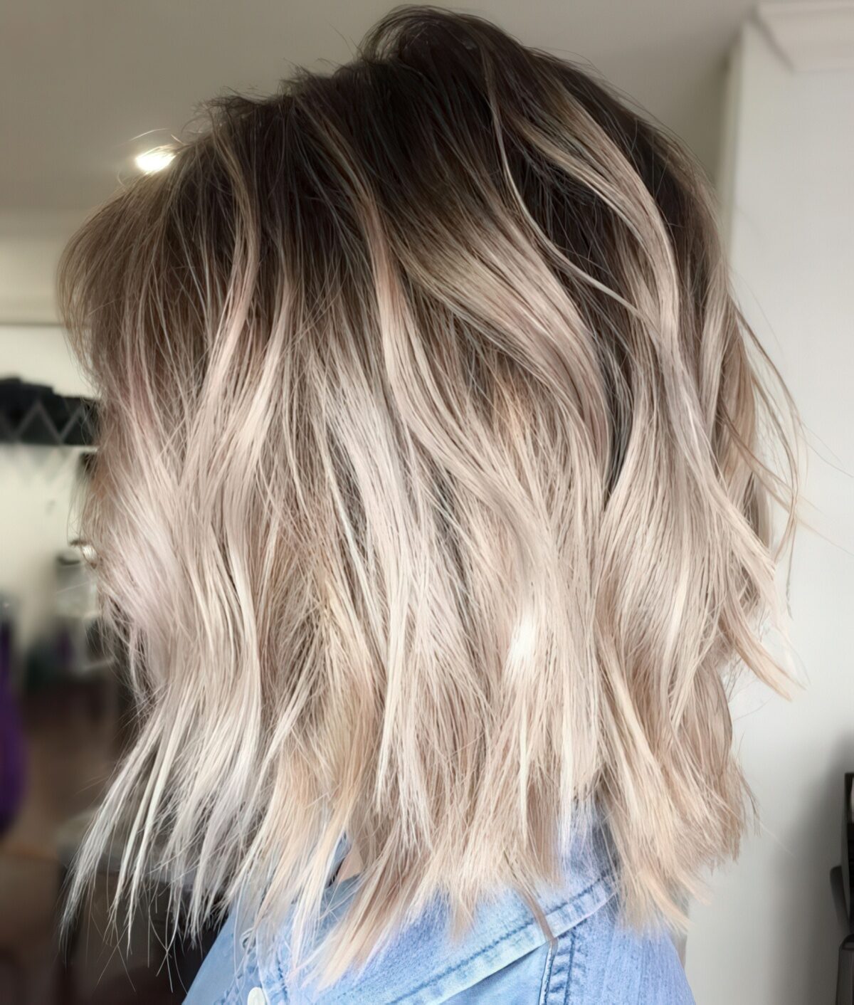 Ashy blonde balayage with root fade on a shaggy bob