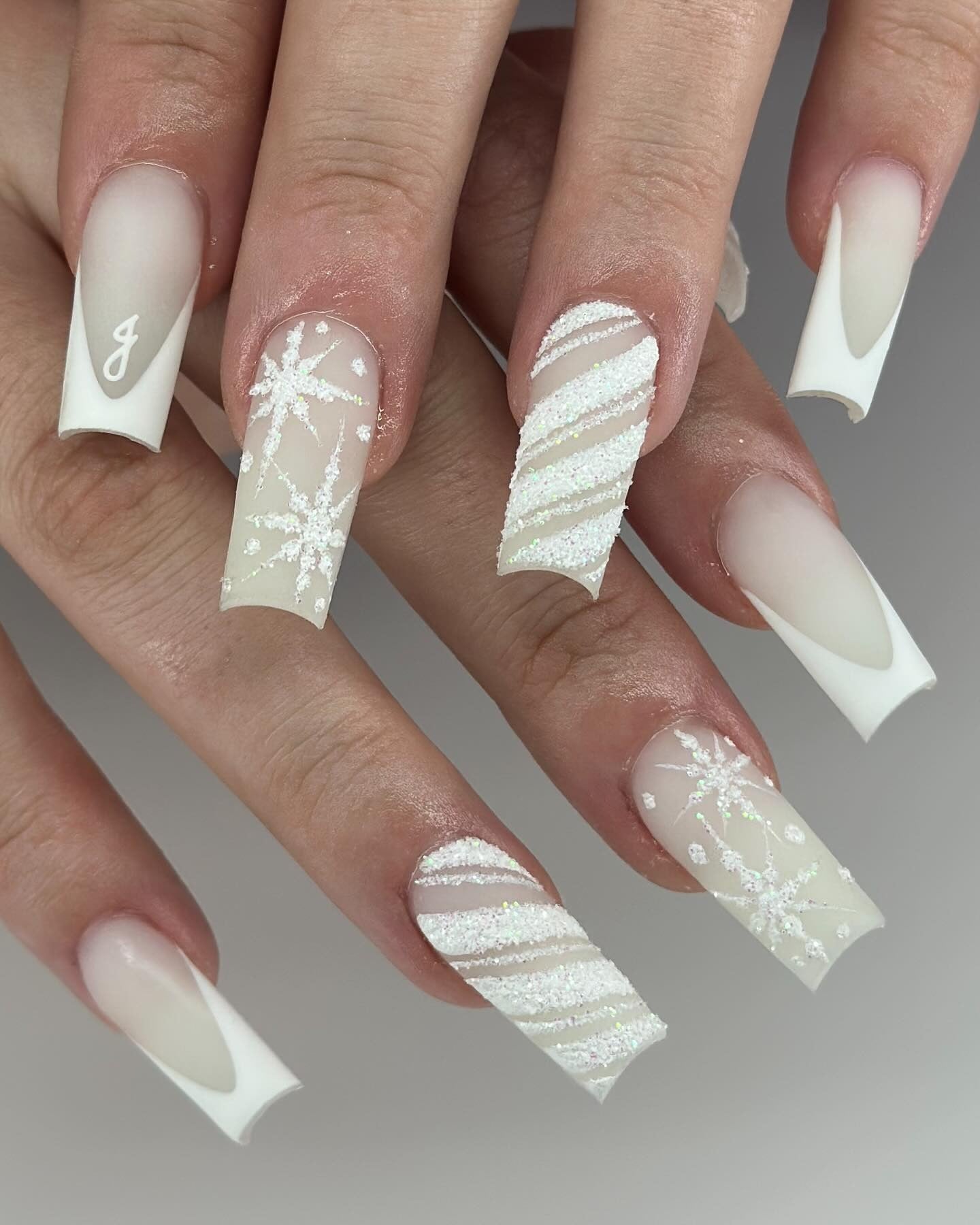 White winter nails with glitter and snowflake design